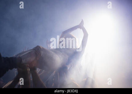 Crowd surfing at a concert in nightclub Stock Photo