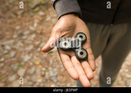 Close-up of a hand s man holding a fidget spinner Stock Photo