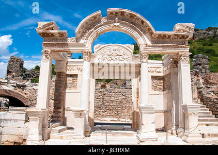 Izmir, Turkey - May 10, 2017: Hadrian's temple ruins with tourists walking around in anceint city of Ephesus on sunny day Stock Photo