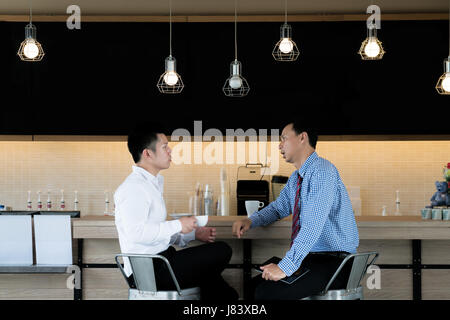 Portrait of casual two Asian business people meeting in cafe for talking and discussing during break. Stock Photo