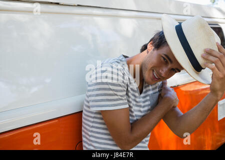 Portrait of man leaning on camper van in the park Stock Photo
