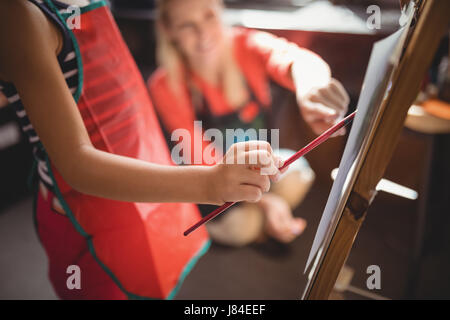 Teacher assisting girl in drawing class at school Stock Photo