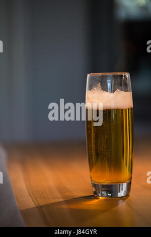 Close up of beer glass on wooden table Stock Photo