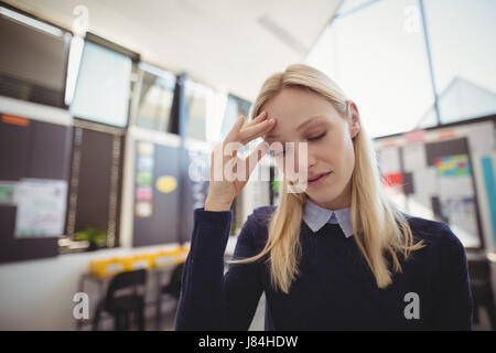 Sad school teacher in classroom at school Stock Photo