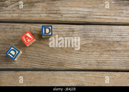 Overhead view of cube shapes with text dad on wooden table Stock Photo