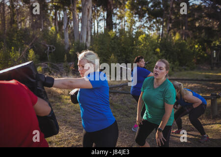 Woman practicing boxing in the boot camp on a sunny day Stock Photo