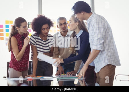 Female manager discussing strategies with creative team in office Stock Photo