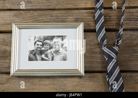 Overhead view of picture frame by necktie on wooden table Stock Photo