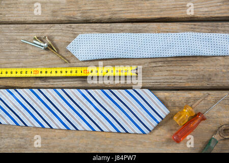 Overhead view of hand tools and neckties on wooden table Stock Photo