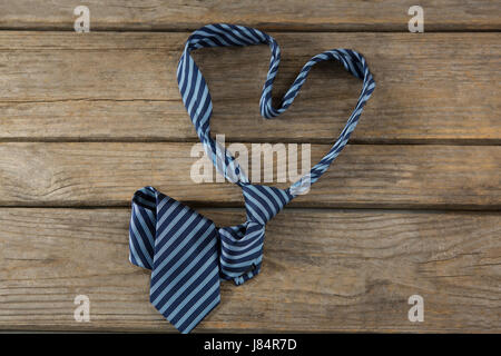 Overhead view of necktie in heart shape on wooden table Stock Photo