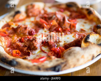 A Neapolitan-style thin crust pizza with Italian sausage and hot peppers from Rosso Pizzeria in Edmonton, Alberta, Canada. Stock Photo