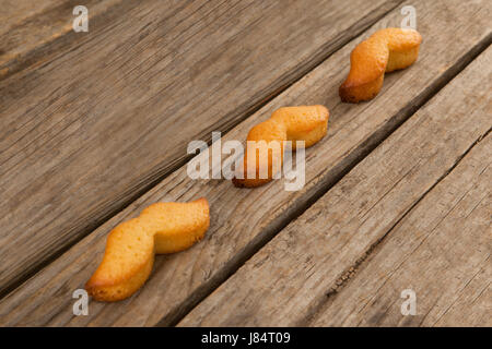Close-up of baked cookies in mustache shape on wooden plank Stock Photo