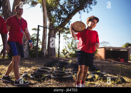 Trainer instructing a boy during obstacle course training in the boot camp Stock Photo