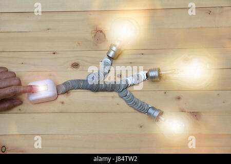 finger push switch for turn on light in bulb light and coins for idea and save money Stock Photo