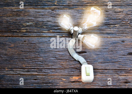 open switch for turn on light in bulb light and coins for idea and save money Stock Photo