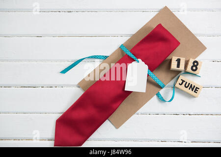 Overhead view of necktie gift by calender on white table Stock Photo