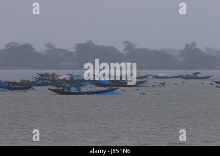 Fishermen fishing on the Poshur River using a wooden boat at Mongla. Bagerhat, Bangladesh. Stock Photo