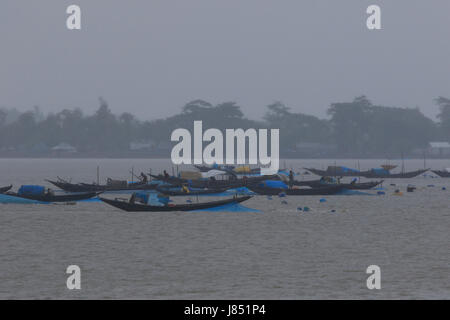 Fishermen fishing on the Poshur River using a wooden boat at Mongla. Bagerhat, Bangladesh. Stock Photo