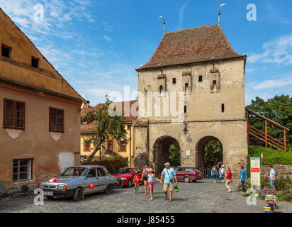 Sighisoara, Romania - July 26, 2014: Tourists visit the old Tailors' Tower (Turnul Croitorilor), raised in the 14th century, restored in 1935. Stock Photo