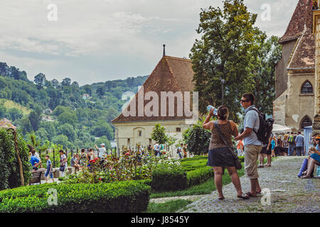 Sighisoara, Romania - July 26, 2014: Tourists relax and enjoy the sights at the famous medieval citadel of Sighisoara. Stock Photo