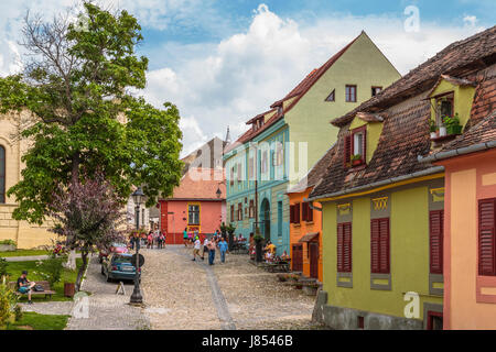 Sighisoara, Romania - July 26, 2014: Tourists stroll the old cobblestone streets in the medieval citadel of Sighisoara. Stock Photo