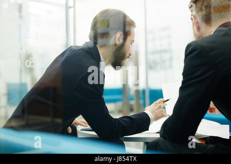 Young traders discussing financial documents in office Stock Photo