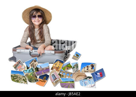 Long haired little girl with straw hat is sitting in a open suitcase. Photos of the sights of Provence (France)  flies around the suitcase. All is on  Stock Photo