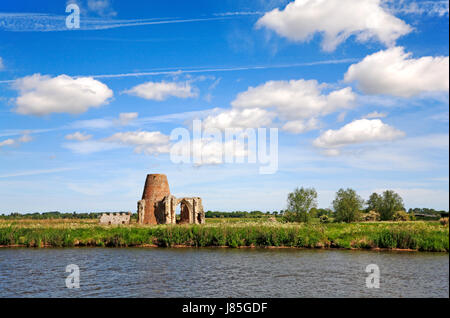 A landscape by the River Bure featuring the disused St Benet's Abbey Drainage Mill and the ruins of the St Benet's Abbey gatehouse. Stock Photo