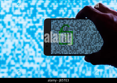 Hand holding a smartphone with a locker unlocked against binary code on screen Stock Photo