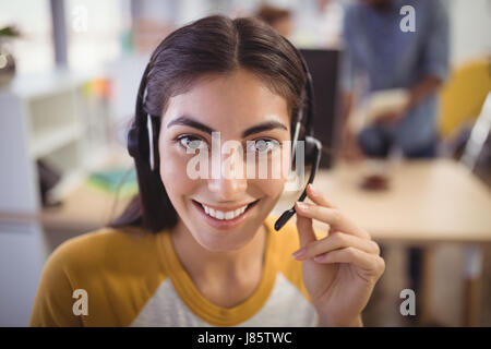 Close up portrait of smiling female customer service representative in office Stock Photo
