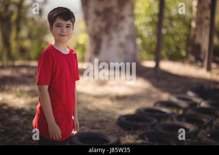 Portrait of smiling boy standing in boot camp during obstacle course Stock Photo