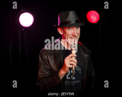 Stand-up comedian performing on stage with microphone Stock Photo