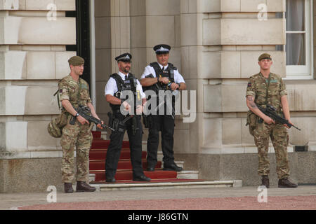 London, UK. 27th May, 2017. Soldiers and police officers carrying rifles on duty at Buckingham Palace after threat level was raised to critical, following the May 22nd Manchester Arena attack. About 1,000 armed military personnel were deployed to guarding national landmarks across the country. Credit: David Mbiyu/Alamy Live News Stock Photo