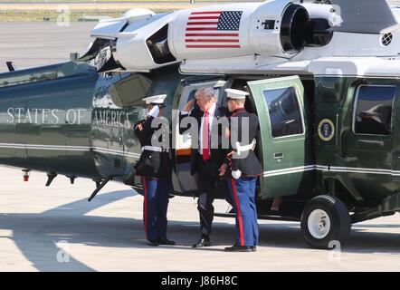 U.S. President Donald Trump salutes as he arrives by helicopter to addresses service members at Naval Air Station Sigonella before returning home from his nine-day overseas trip May 27, 2017 in Sigonella, Italy. Stock Photo