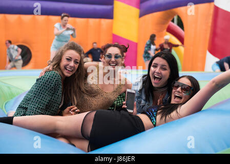 Southampton, Hampshire, UK. 27th May 2017. Friends bounce on the worlds biggest bouncy castle together. Common People Music Festival returns in 2017 to Southampton Common where the Bestival team, along with curator, Rob Da Bank, have put together a fantastic lineup of acts. Event security remains tight after the recent terror attack in Manchester resulting in the UK terror threat level being escalated from 'Severe' to 'Critical'. Despite these anxieties, festival goers haven't been put off and are determined to enjoy the festivities, live music and sunshine. Credit: Will Bailey/Alamy Live News Stock Photo