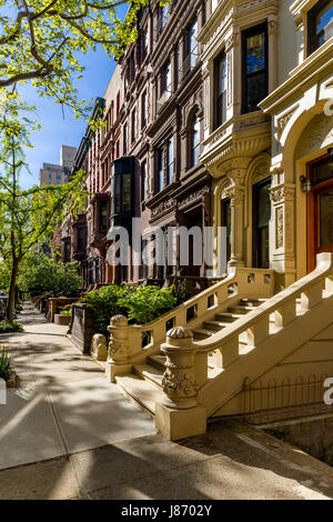 Row of brownstones with doorsteps and ornament in morning light. Upper West Side Street, Manhattan, New York City Stock Photo