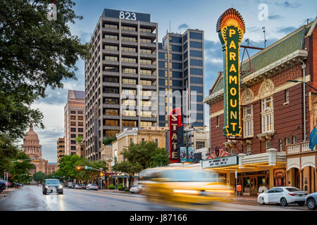 Cars pass on Congress Avenue with theaters and office buildings in the background in downtown Austin, Texas, USA Stock Photo