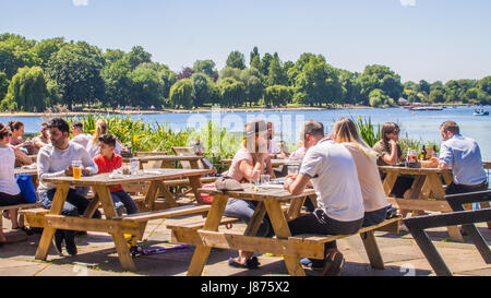 People sitting at an outdoor restaurant by the Serpentine Lake in Hyde Park, London Stock Photo