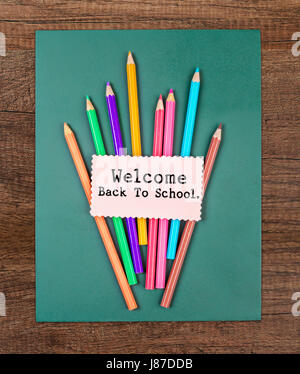 welcome back to school word and color pencil on green chalkboard on wooden background. Stock Photo