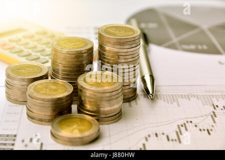 money coins with graph paper and calculator, finance and growth of business Stock Photo