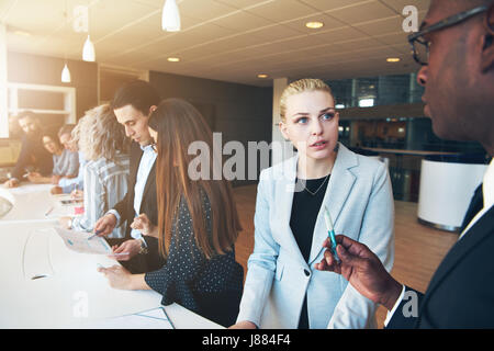 Black and white men and women working in modern office discussing and planning work during the conference. Stock Photo