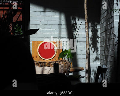 Mock up blank signage on table in urban restaurant cafe shop on the white brick vintage background. Stock Photo