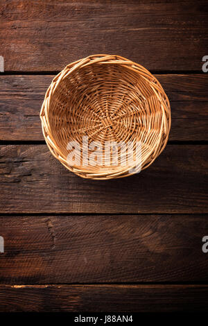 Empty wicker basket on a wooden background, top view Stock Photo