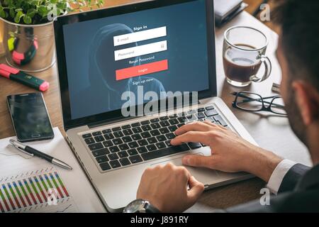 Internet security concept - Young man in his office, login on the laptop screen Stock Photo