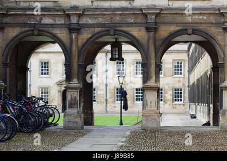 Students robe on a lamppost after graduation underneath the Decorative archways leading the Cambridge university Stock Photo