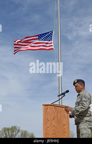 Senior Airman Eduardo Virgil, 5th Security Forces Squadron member, recites fallen officers’ names during a National Police Week retreat ceremony at Minot Air Force Base, N.D., May 19, 2017. A retreat ceremony is the daily military practice of lowering the flag. (U.S. Air Force photo/Airman 1st Class Austin M. Thomas) Stock Photo