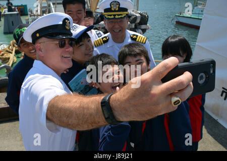 170519-N-WC492-024 SHIMODA, Japan (May 19, 2017) Command Master Chief Joseph Fahrney, U.S. Naval Forces Japan, Navy Region Japan takes a selfie with Capt. Jeffrey Kim, commander, Fleet Activities Yokosuka and some Japanese students during the first day of the 78th Shimoda Black Ship Festival.  The Navy’s participation in the festival celebrates the heritage of U.S.-Japanese naval partnership first established by Commodore Matthew Perry’s 1853 port visit. (U.S. Navy photo by Daniel A. Taylor/Released) Stock Photo