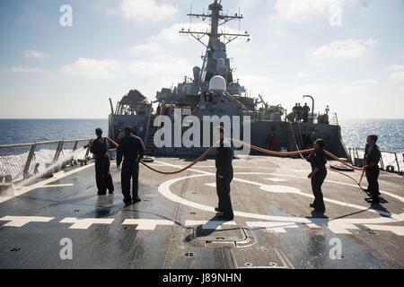 170524-N-FQ994-071 MEDITERRANEAN SEA (May 24, 2017) Sailors aboard the Arleigh Burke-class guided-missile destroyer USS Ross (DDG 71) man a water hose during a fresh water washdown May 24, 2017. Ross, forward-deployed to Rota, Spain, is conducting naval operations in the U.S. 6th Fleet area of operations in support of U.S. national security interests in Europe and Africa. (U.S. Navy photo by Mass Communication Specialist 3rd Class Robert S. Price/Released) Stock Photo