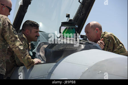 Senior Airman Christopher Caruso, 455th Expeditionary Aircraft Maintenance Squadron, speaks with Gen. Mike Holmes, commander of Air Combat Command, about the capabilities of the F-16 Fighting Falcon at Bagram Airfield, Afghanistan, May 25, 2017. Holmes commanded the 455th Air Expeditionary Wing from March 2008 to April 2009. (U.S. Air Force photo by Staff Sgt. Benjamin Gonsier) Stock Photo