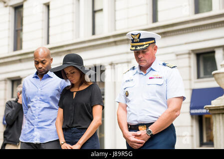Cast members Brandon Victor Dixon (Aaron Burr) and Lexi Lawson (Eliza Hamilton) of the esteemed Broadway musical, Hamilton, bow their heads in a moment of silence with Capt. Scott Clendenin, commanding officer of the Coast Guard Cutter Hamilton to honor the shared namesake of the Cutter Hamilton and the play, founder of the Coast Guard, Alexander Hamilton, at his grave at Trinity Church in New York City, May 26, 2017. The wreath-laying ceremony was part of Fleet Week New York and Memorial Day weekend activities. U.S. Coast Guard photo by Petty Officer 1st Class LaNola Stone. Stock Photo